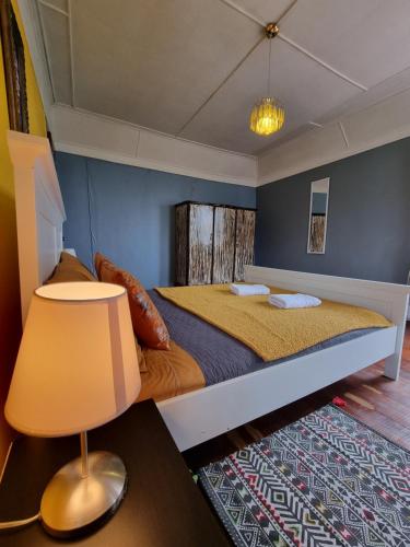 a bedroom with a bed with a lamp and a rug at Meraki Hostel - Cerro Alegre - Valparaíso in Valparaíso