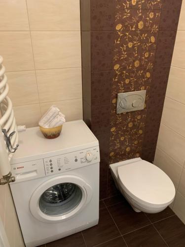 a bathroom with a washing machine and a toilet at Apartament Nuldenovski Resort Grzybowo in Grzybowo