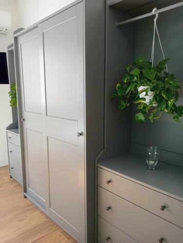 a white cabinet with a potted plant on top of it at Dom Apartment Luxury in Cagliari