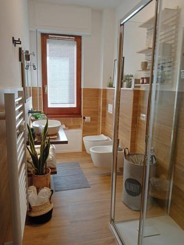 a bathroom with a shower and two sinks and a toilet at Dom Apartment Luxury in Cagliari