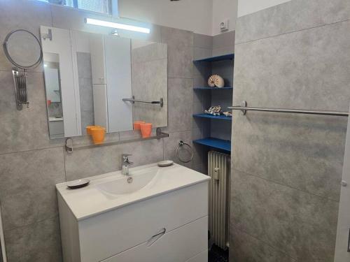 une salle de bain avec un lavabo blanc et un miroir dans l'établissement Le Loft Blainville, à Dieppe