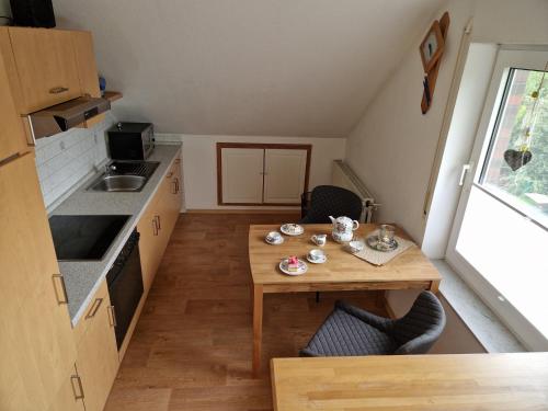 een kleine keuken met een houten tafel in een tiny house bij Ferienwohnung Renken in Upgant-Schott