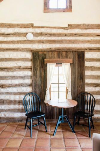 a table and two chairs in a room with wooden walls at Contigo Ranch Fredericksburg in Fredericksburg