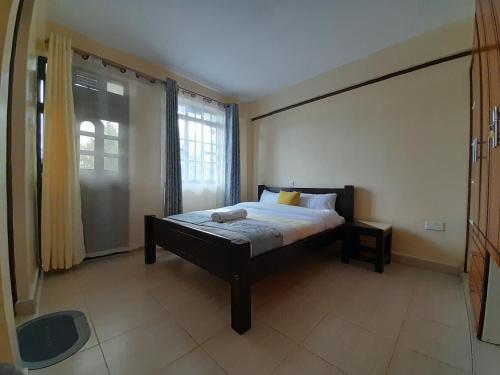 a bedroom with a bed and a large window at Milimani Nanyuki in Nanyuki