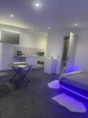 1 dormitorio con cama y mesa con iluminación púrpura en Studio ensoleillé sur Montpellier en Montpellier
