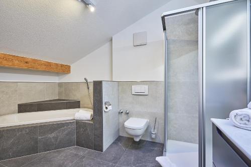 een badkamer met een douche, een toilet en een wastafel bij Gästehaus Angerer in Reit im Winkl