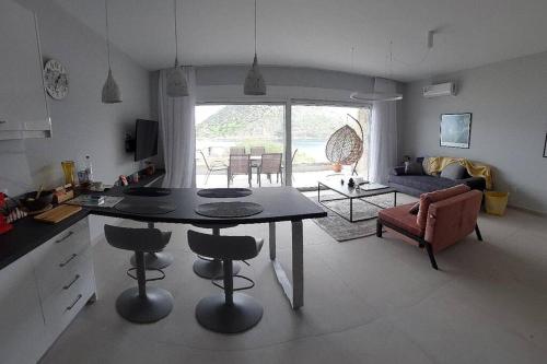 a kitchen and living room with a table and chairs at Gesyl Apartment in Tolo