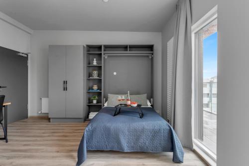 een slaapkamer met een bed en een groot raam bij B18 Apartments in Reykjavík