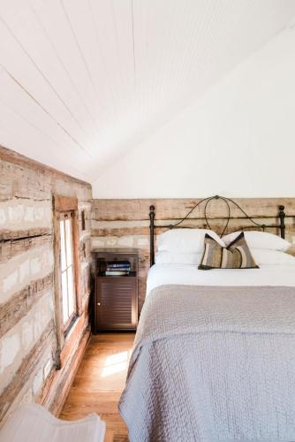 a bedroom with a bed and a wooden wall at Contigo Ranch Fredericksburg in Fredericksburg