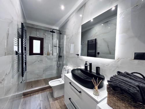 a white bathroom with a sink and a toilet at Modiano Luxury Apartment Thessaloniki in Thessaloniki