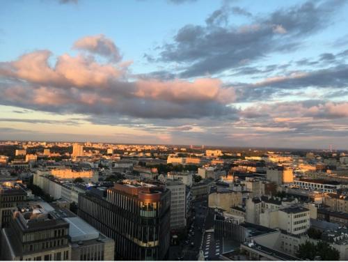 a view of a city at sunset with clouds at ComeWa Apartments in Warsaw