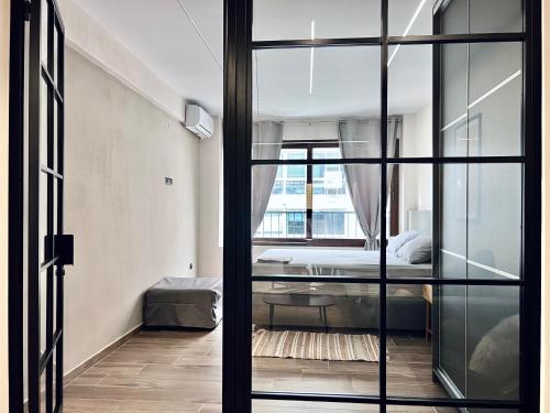 a bedroom with a bed and a glass door at Modiano Luxury Apartment Thessaloniki in Thessaloniki