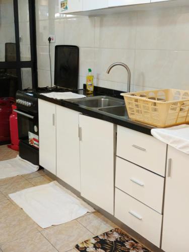 a kitchen with white cabinets and a sink at Kaisa gardens in Nairobi