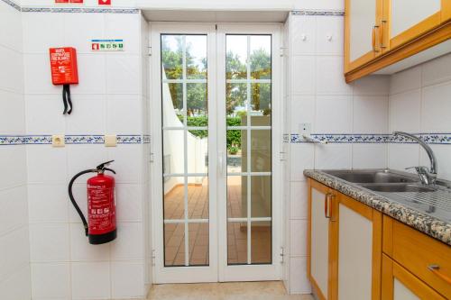 a kitchen with a fire extinguisher on the wall at Vila do Castelo in Albufeira