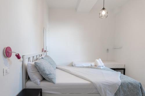a white bedroom with a bed with a light fixture at Saragozza Apartments - Bologna Short Rental in Bologna