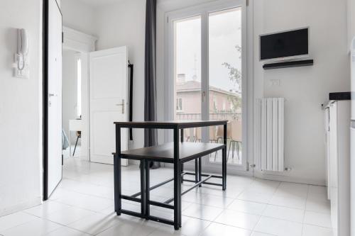 a black stool in a white room with a window at Saragozza Apartments - Bologna Short Rental in Bologna