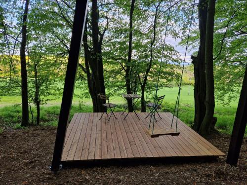 a wooden deck with two chairs and a table on it at Posed STRÁŽNICE in Budišovice