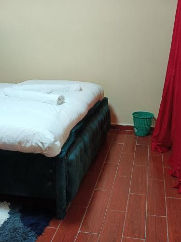 a bed sitting in a room with red curtains at Kaisa gardens in Nairobi