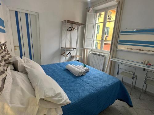 a bedroom with a blue bed and a desk at Affittacamere Via Prione in La Spezia