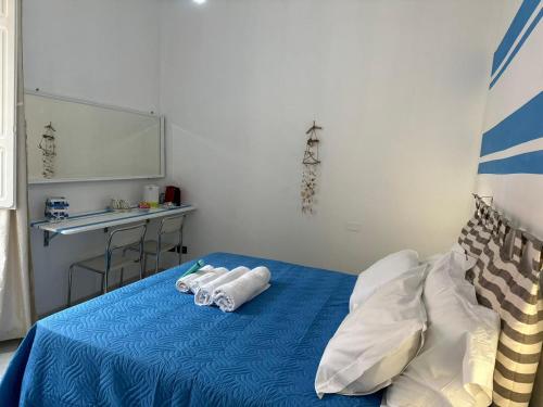 a bedroom with a blue bed with towels on it at Affittacamere Via Prione in La Spezia