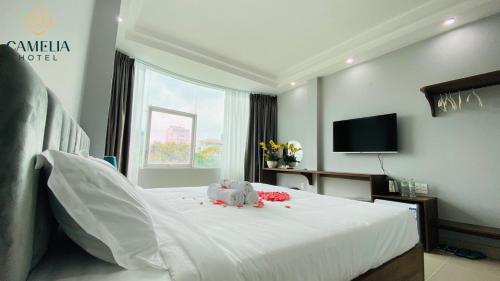 胡志明市的住宿－Camelia 108 Le Lai Hotel，卧室配有白色的床,上面有大象填充物