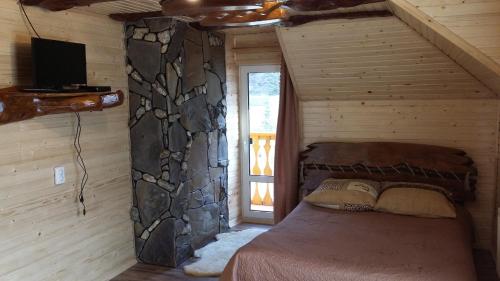 a bedroom with a bed in a log cabin at Ilkova Sadyba in Yaremche