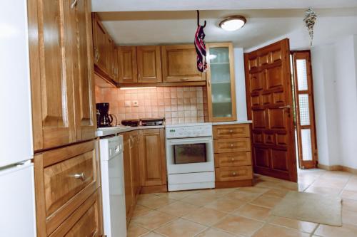een keuken met houten kasten en een witte kookplaat bij To Petrino 