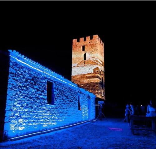 a large brick building with a tower at night at Artemis House in Nea Fokea