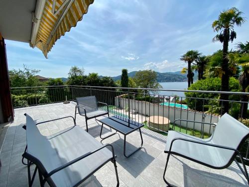 a patio with chairs and tables and a view of the water at A dream on the lake in Ranco