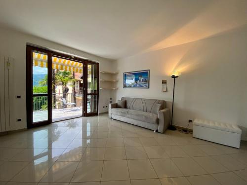 a living room with a couch and a large window at A dream on the lake in Ranco