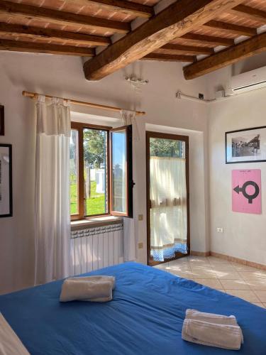 a bedroom with a blue bed and a window at San Martino - Casa Landi in Castellina in Chianti