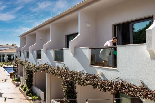 a man looking out the window of a building at The Magnolia Hotel in Quinta do Lago