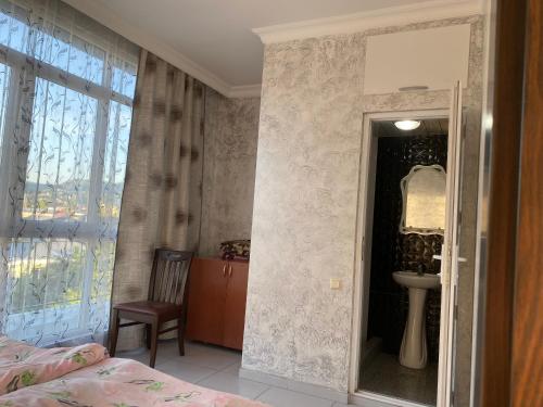 sypialnia z łóżkiem, umywalką i lustrem w obiekcie Merab House w mieście Batumi