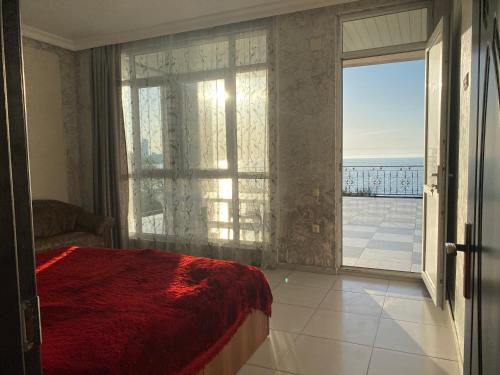 a bedroom with a large window with a view of the ocean at Merab House in Batumi