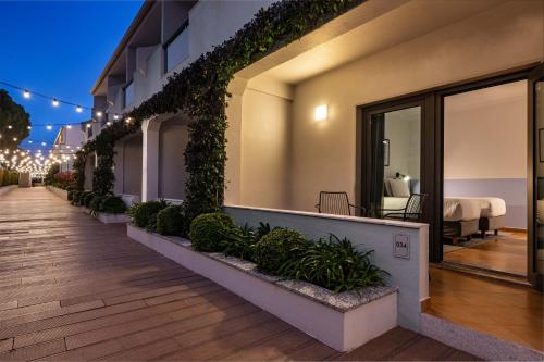 a balcony of a building with plants and lights at The Magnolia Hotel in Quinta do Lago