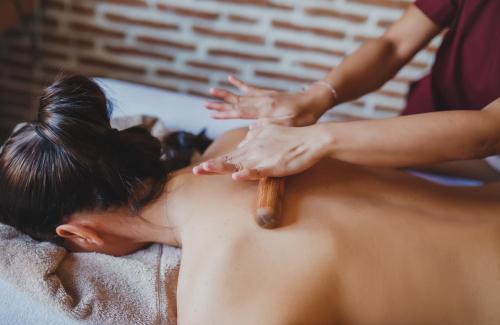 a woman getting a massage with a wooden stick at Luxury Two Bedroom Penthouse in Caesar Resort & SPA, Long Beach in Perivolia tou Trikomou