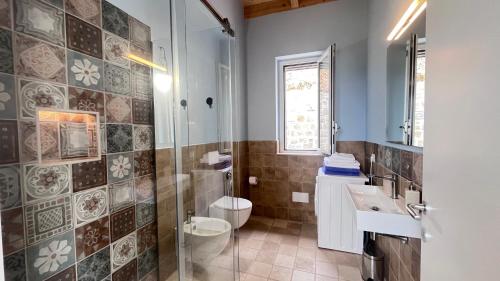 y baño con ducha, aseo y lavamanos. en Casale 54, en San Giorgio