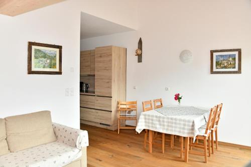 ein Esszimmer mit einem Tisch, Stühlen und einem Sofa in der Unterkunft Botenhof - Urlaub auf dem Bauernhof - Agriturismo in Sarntal