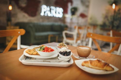 a table with two plates of food and a cup of coffee at Luxury Two Bedroom Penthouse in Caesar Resort & SPA, Long Beach in Perivolia tou Trikomou