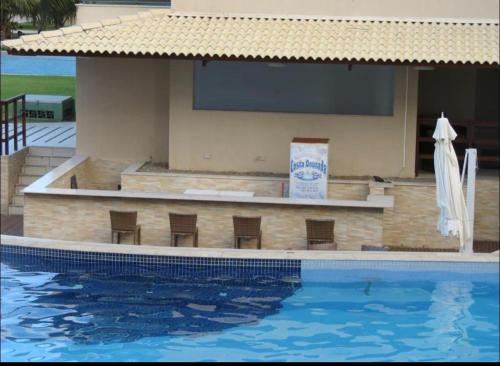 a swimming pool with chairs next to a building at Ekoara Residence - Muro Alto in Porto De Galinhas