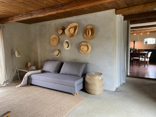 ein Wohnzimmer mit einem Sofa und Hüten an der Wand in der Unterkunft Rönnebröd in Rönnebröd