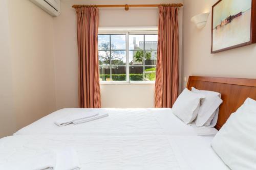 a bedroom with a bed and a window at Vila do Castelo in Albufeira