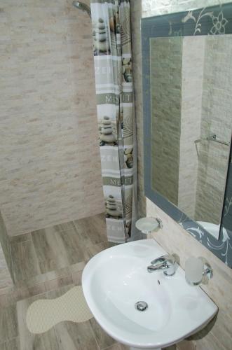 a bathroom with a white sink and a mirror at Apartament Salcia in Galaţi
