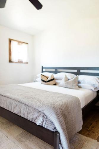 a bedroom with a large bed with white walls at Contigo Ranch Fredericksburg in Fredericksburg
