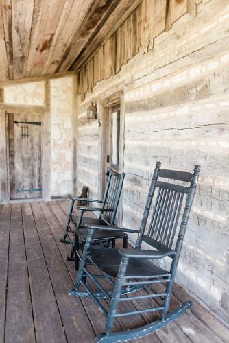 two rocking chairs sitting on the porch of a building at Contigo Ranch Fredericksburg in Fredericksburg