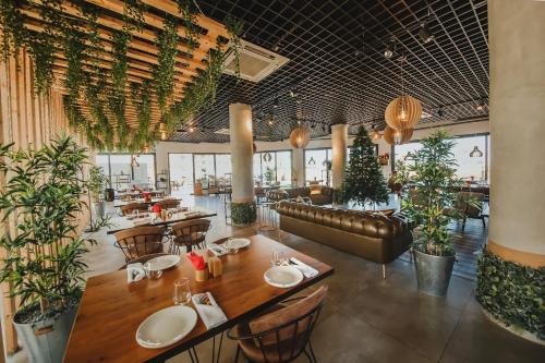a restaurant with tables and chairs and plants at Luxury Two Bedroom Penthouse in Caesar Resort & SPA, Long Beach in Perivolia tou Trikomou