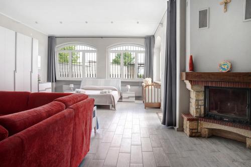 a living room with a red couch and a fireplace at La casa del Pue in Bene Vagienna