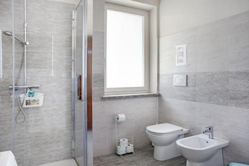 a bathroom with a toilet and a sink and a shower at La casa del Pue in Bene Vagienna