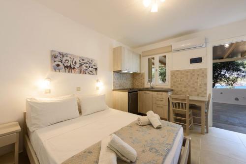 a small bedroom with a bed and a kitchen at Sea Breeze Studios Paros in Aliki