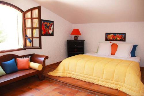 um quarto com uma cama, uma janela e uma cadeira em Quiet villa with swimming pool near Monaco em Peille